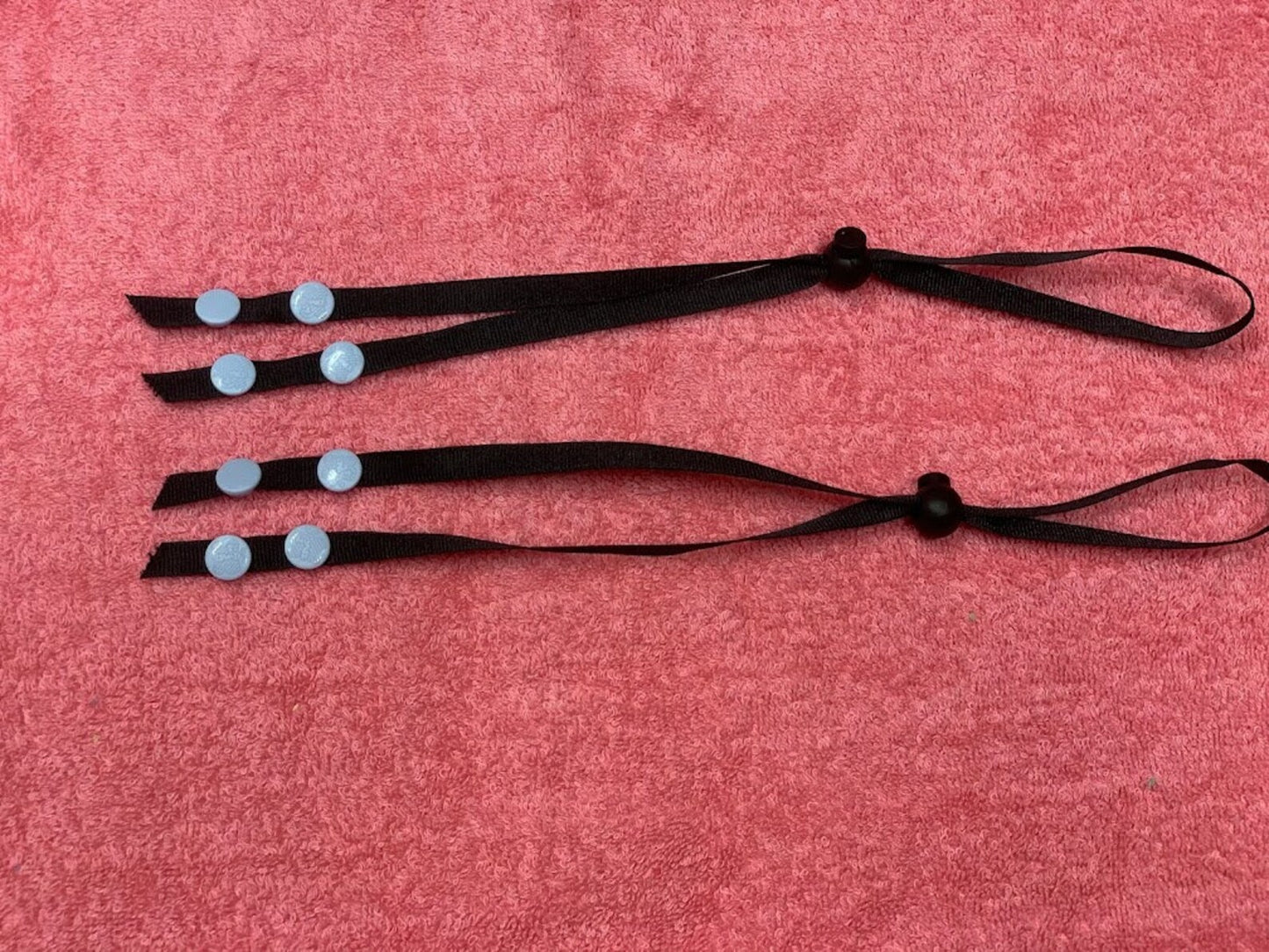 Picture of 2 black lanyards against a red background